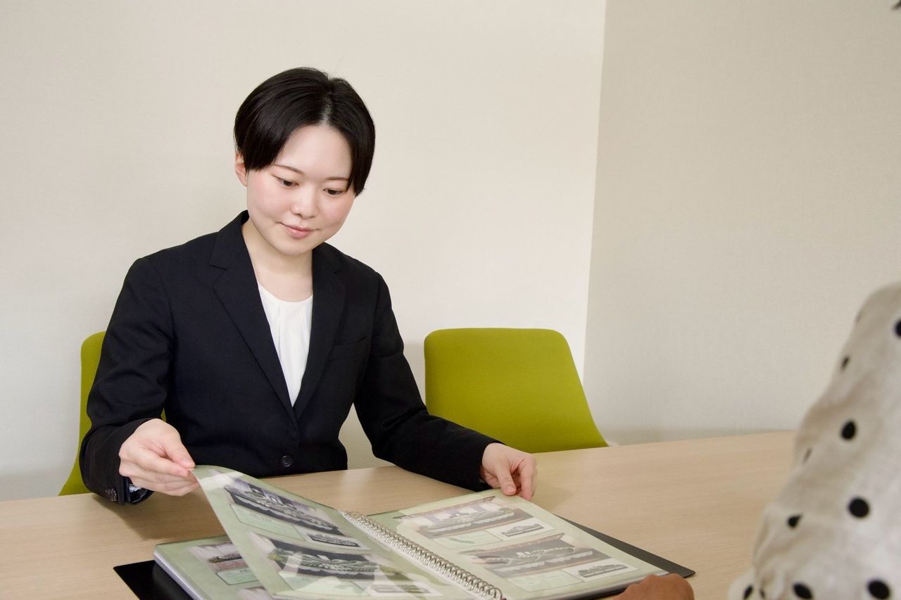 カタログを見ながら、葬儀の内容と料金をご説明する代表の酒井