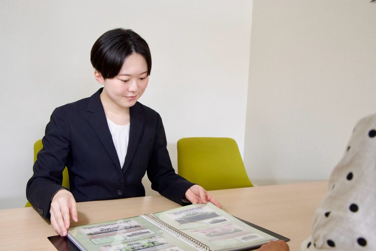 ご相談の席で資料を開く代表の酒井